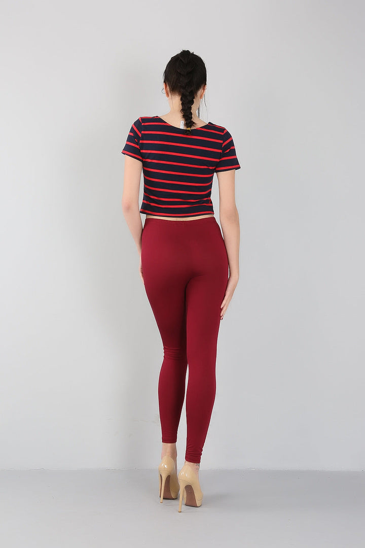 Frau in rot-blau gestreiftem T-Shirt und roten Leggings, Rückansicht, Mode, Freizeitkleidung.