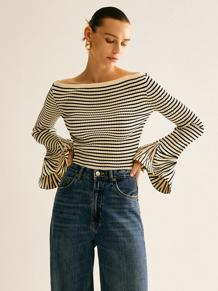 Frau in gestreiftem Langarmshirt und Jeans, modisch, elegant, lässiger Stil, goldene Ohrringe.