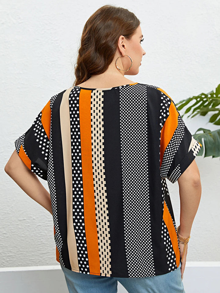 Frau trägt gestreiftes, gepunktetes T-Shirt in Schwarz, Orange und Beige, Rückansicht.