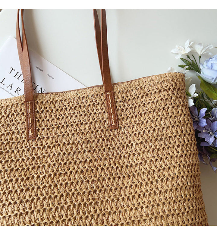 Geflochtene Strohtasche mit braunen Ledergriffen, Blumen und Zeitschrift, Sommermode Accessoire.