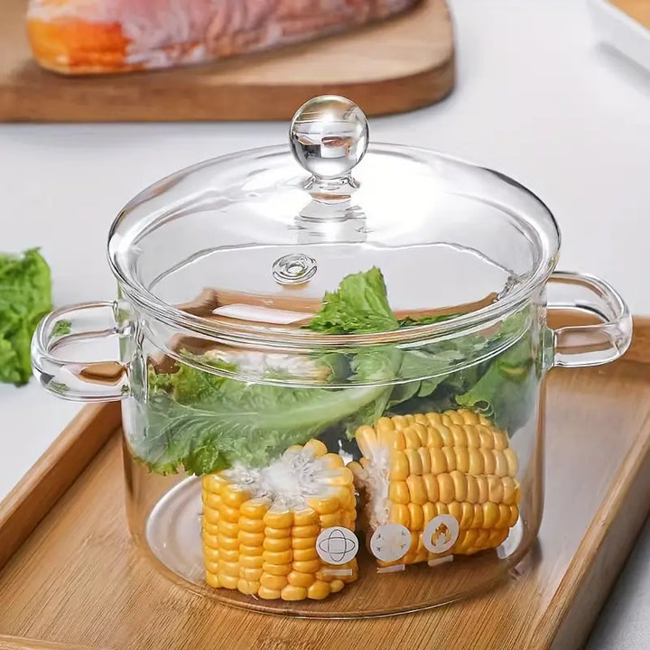 Transparenter Glas-Topf mit Deckel, gefüllt mit Maiskolben und Salat, auf Holztablett.