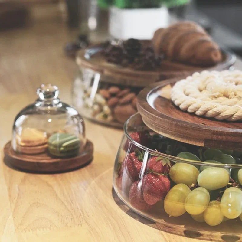 Glasbehälter mit Holzdeckel, gefüllt mit Obst und Gebäck, auf Holztisch, Küchendekoration.