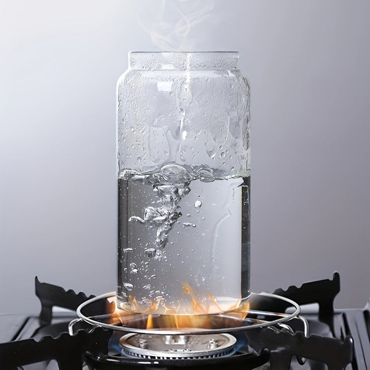 Glasgefäß mit kochendem Wasser auf Gasherd, Dampf steigt auf, transparente Küche.