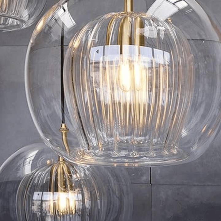 Moderne Glaspendelleuchte mit goldenen Akzenten, transparentes Design, elegantes Wohnaccessoire.