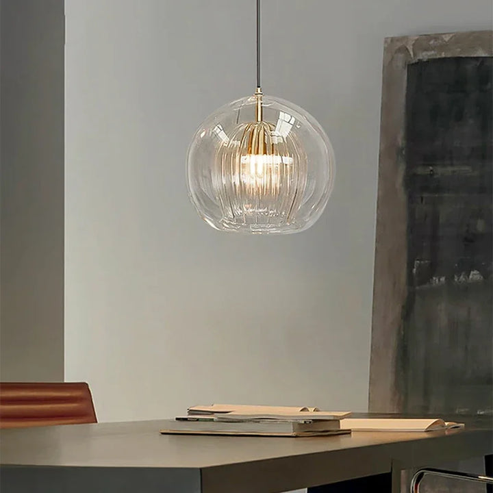 Moderne Glas-Pendelleuchte über Tisch, transparent, elegantes Design, Innenbeleuchtung.