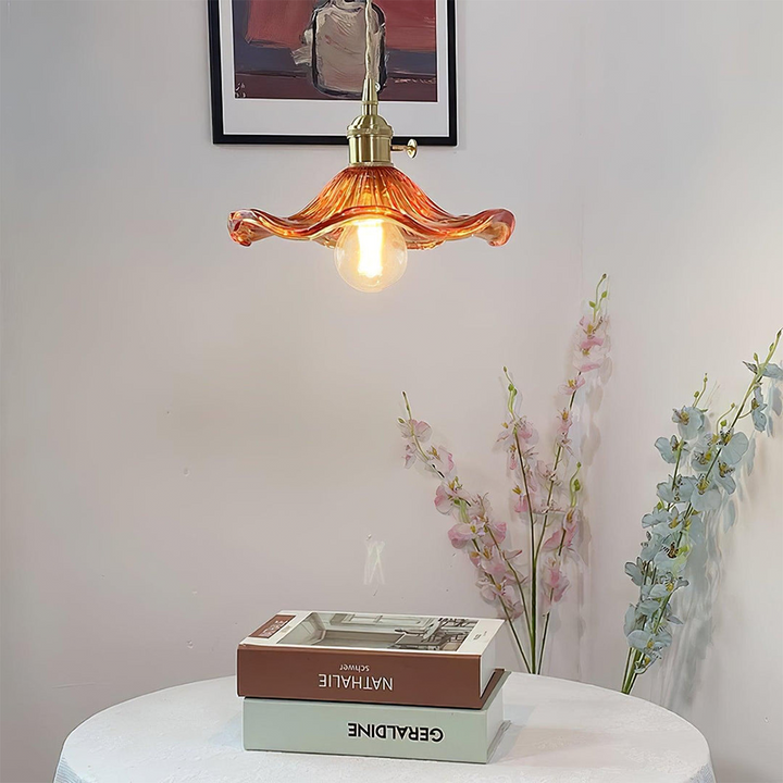 Vintage Pendelleuchte aus Glas, orange, über Tisch mit Blumen und Büchern, Retro-Innenbeleuchtung.