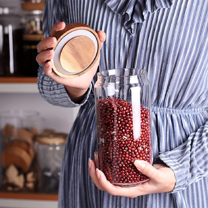 Frau hält Glasbehälter mit roten Bohnen und Holzdeckel, Küche, Vorratsglas, Aufbewahrung.