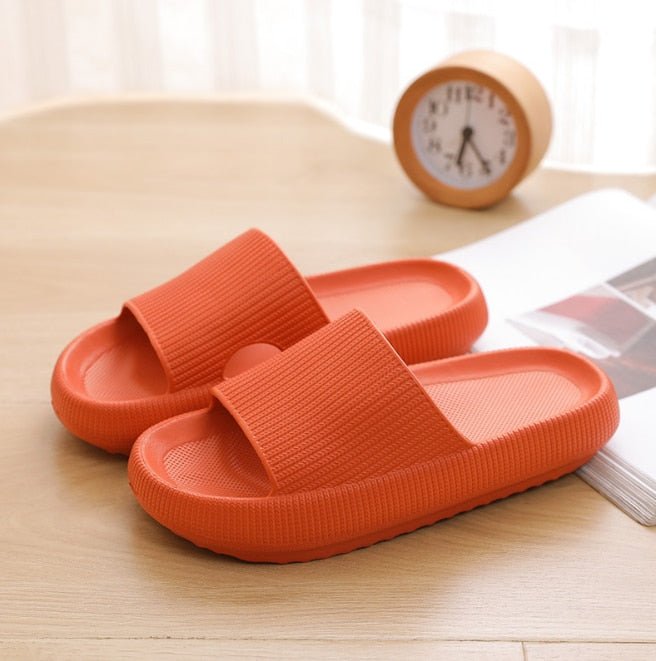 Orange Pantoletten aus Gummi auf Holztisch, bequemes Design, ideal für den Sommer.
