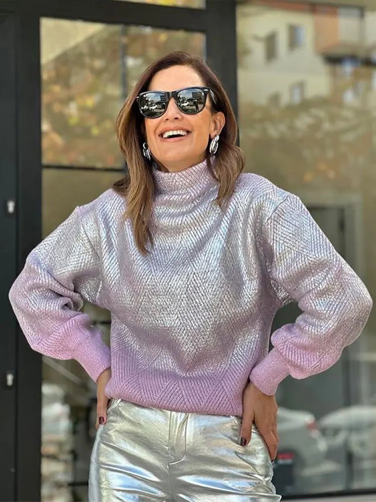 Frau in schimmerndem, metallischem Strickpullover mit hohem Kragen und langen Ärmeln, modisch.