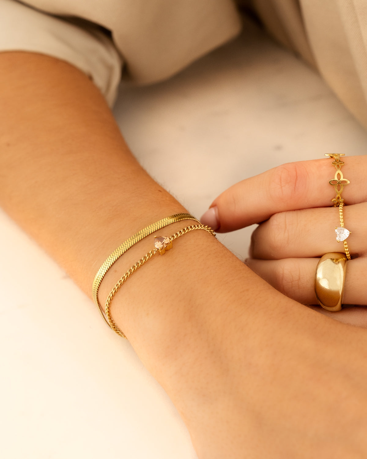 Goldene Armbänder und Ringe auf Hand, Schmuck, elegant, modisch, Damenaccessoires.