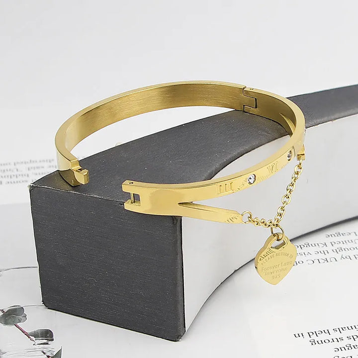 Goldenes Edelstahl-Armband mit Herzanhänger und Strasssteinen, elegantes Schmuckdesign.
