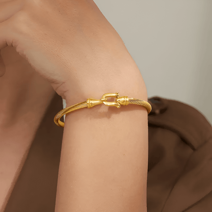 Goldenes Armreif aus Edelstahl, elegantes Design, Damenmode, Schmuckaccessoire.