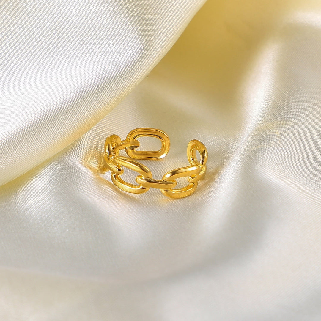 Goldener Kettenring auf weißem Satin, verstellbar, modisches Schmuckstück, elegantes Design.