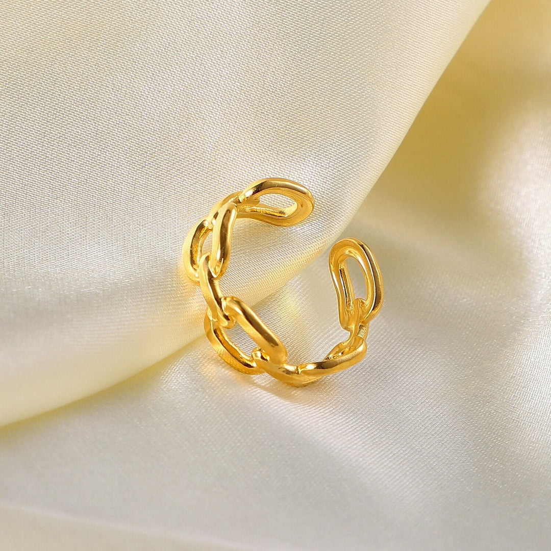 Goldener Kettenring auf cremefarbenem Satin, eleganter Schmuck, modisches Accessoire.