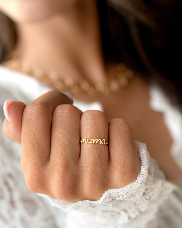 Goldener "mama" Ring, Damenhand, filigran, Schmuck, Geschenk, Modeaccessoire, Nahaufnahme.