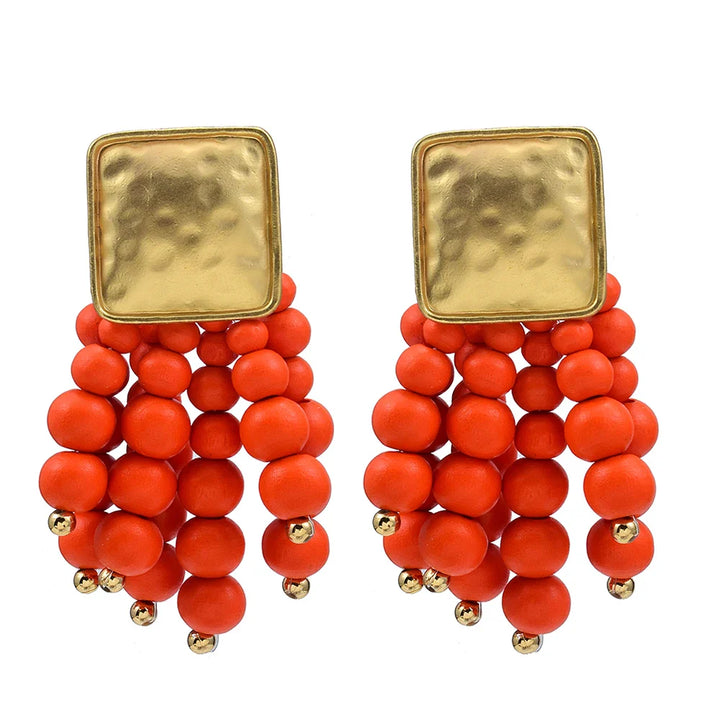 Goldene Ohrringe mit roten Perlen, modisches Accessoire, elegantes Design, Damen-Schmuck.