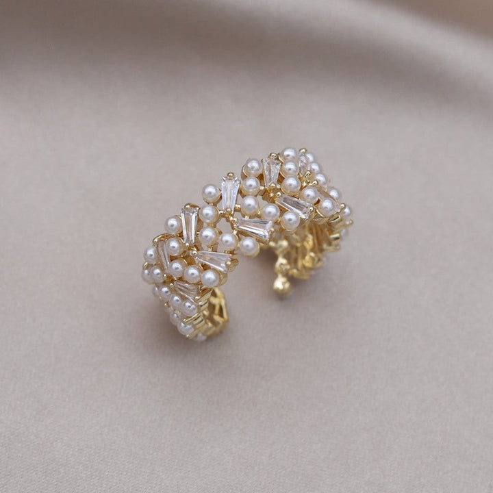 Goldener Perlenring mit Kristallen, elegantes Schmuckdesign, luxuriöses Accessoire für Damen.