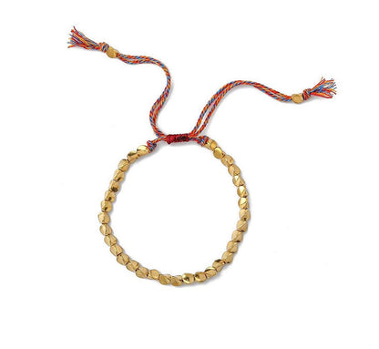 Goldfarbenes Armband mit buntem Kordelverschluss, handgefertigt, modisches Accessoire.