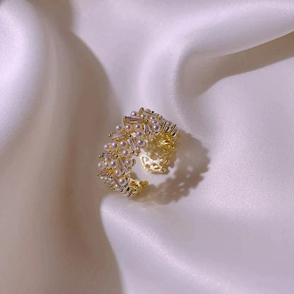 Goldener Perlenring auf weißem Satin, eleganter Schmuck, luxuriöses Design.