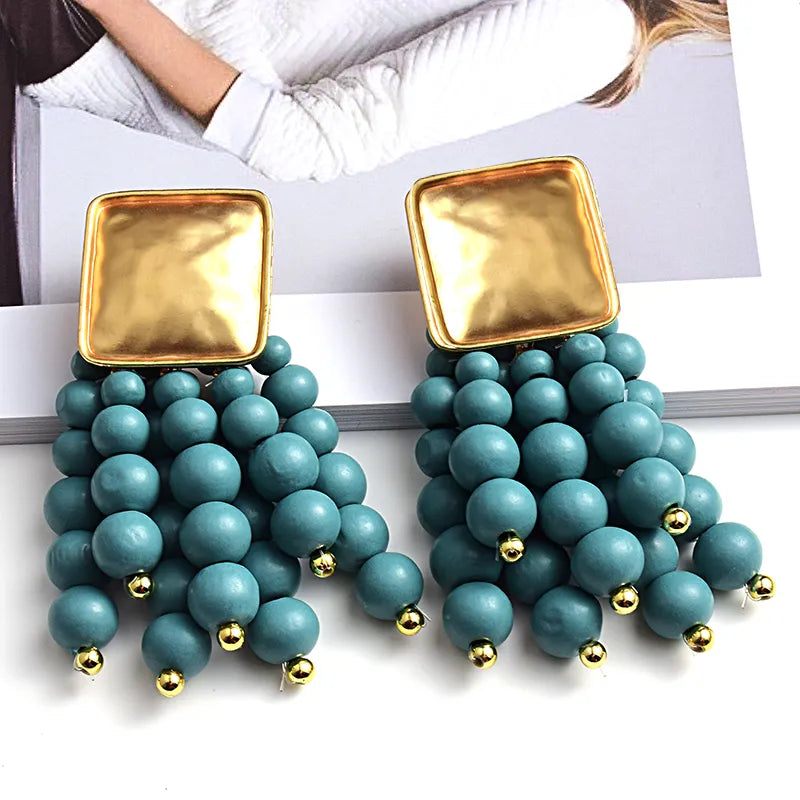 Goldene Ohrringe mit türkisfarbenen Perlen, quadratischer Anhänger, modisches Schmuckdesign.