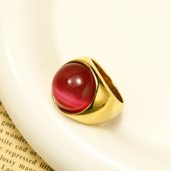 Goldener Ring mit rotem Katzenauge-Stein, eleganter Schmuck, modisches Accessoire.