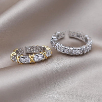 Zwei elegante Ringe mit Diamanten, einer in Gold, der andere in Silber, auf Seidenstoff.