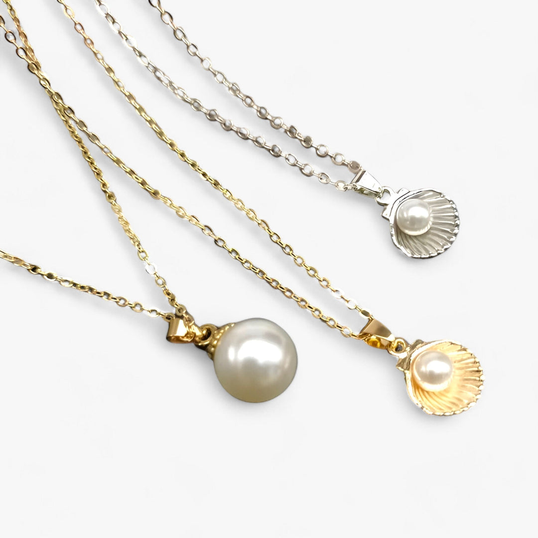 Drei Halsketten mit Perlenanhängern, Gold- und Silberketten, eleganter Schmuck, Nahaufnahme.