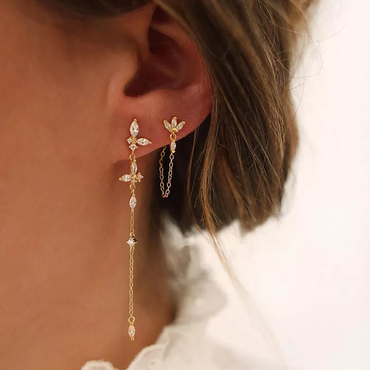 Goldene Ohrringe mit Ketten und Kristallen, elegantes Design, Schmuck für Frauen.