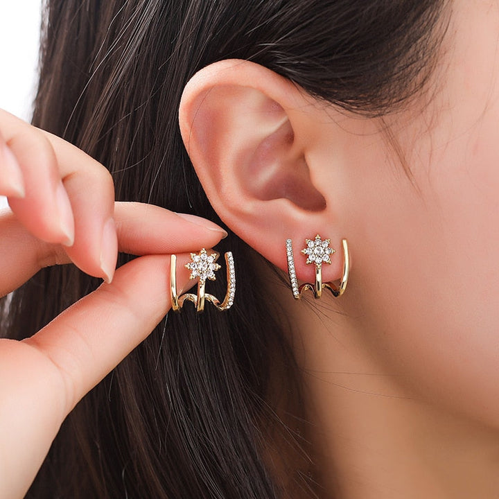 Goldene Ohrringe mit funkelnden Sternen und Strasssteinen, eleganter Schmuck für Damen.