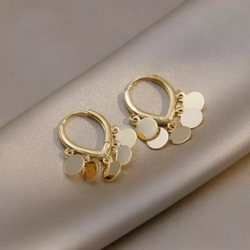 Goldene Creolen Ohrringe mit runden Anhängern, eleganter Schmuck, modisch, Damenaccessoire.