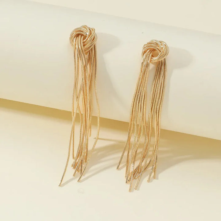 Goldene Knoten-Ohrringe mit langen Fransen, eleganter Schmuck für Damen, modisches Accessoire.