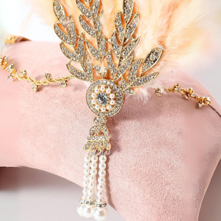 Goldene Strass-Haarspange mit Perlen und Federn auf rosa Hintergrund, eleganter Haarschmuck.