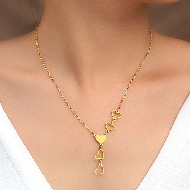 Goldene Halskette mit Herzanhängern, Damenmode, eleganter Schmuck, Geschenkidee.