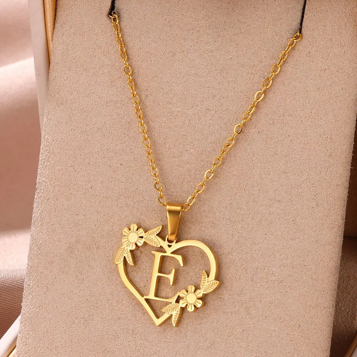 Goldene Herz-Halskette mit Blumen und Buchstabe E, elegantes Schmuckdesign, Geschenkidee.