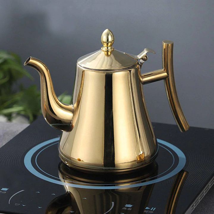 Goldene Edelstahl-Teekanne auf Induktionsherd, modernes Design, glänzend, Küche.