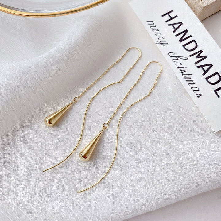 Goldene, lange Ohrringe aus Edelstahl, minimalistisch, handgefertigt, elegantes Schmuckdesign.