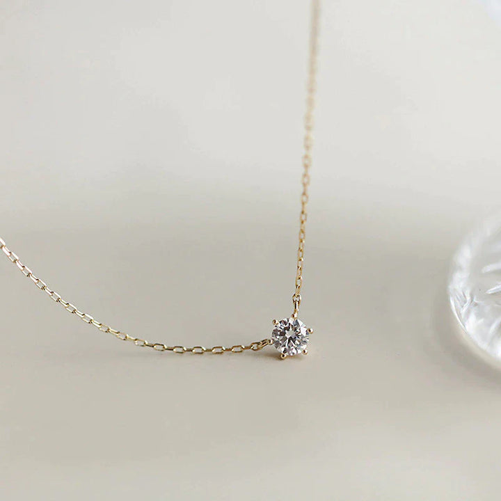 Goldene Halskette mit Diamantanhänger, eleganter Schmuck, minimalistisches Design.