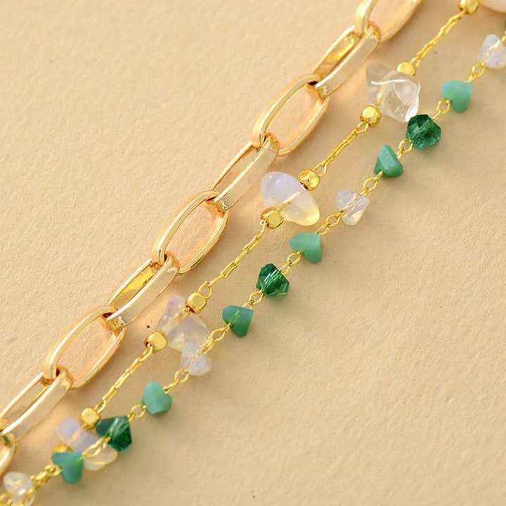 Goldene Kettenarmbänder mit grünen und klaren Edelsteinen, Damen- und Herrenschmuck.