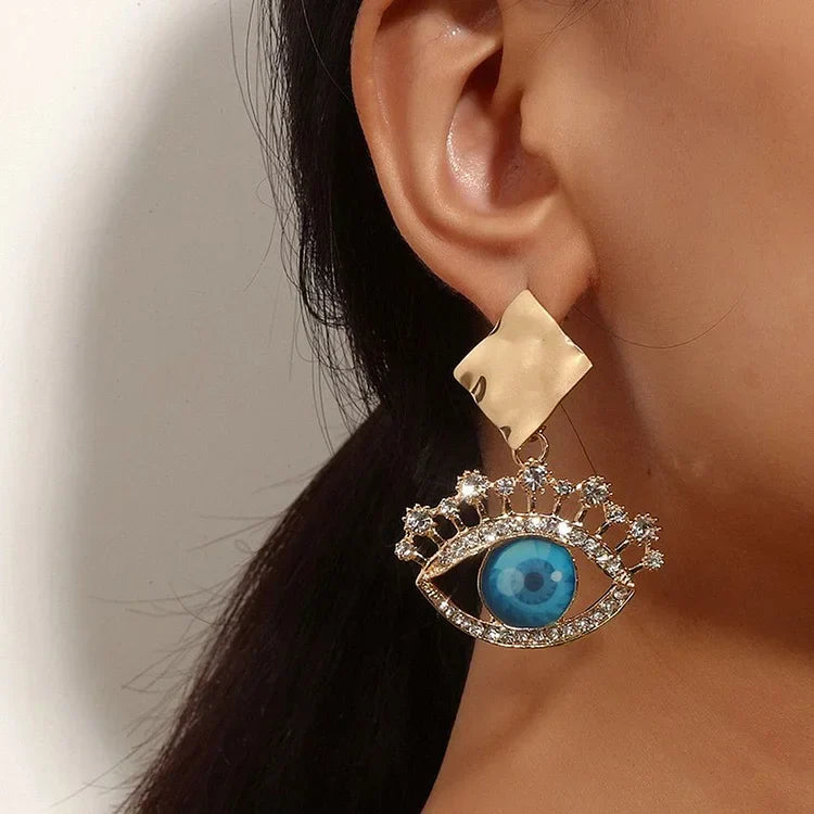 Goldene Ohrringe mit blauem Auge und Strasssteinen, modisches Schmuckdesign für Damen.