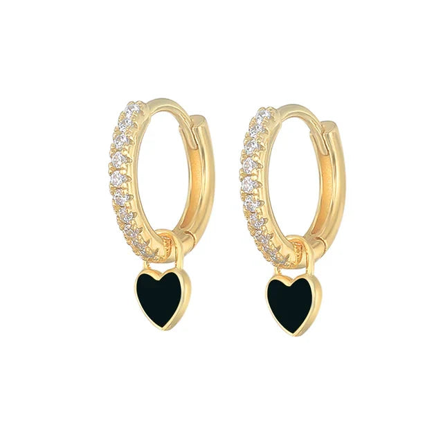 Goldene Creolen mit schwarzen Herzanhängern und Kristallakzenten, eleganter Schmuck.
