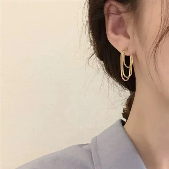 Goldene Creolen Ohrringe, doppelt, elegant, Damenmode, Schmuckaccessoire, Nahaufnahme.