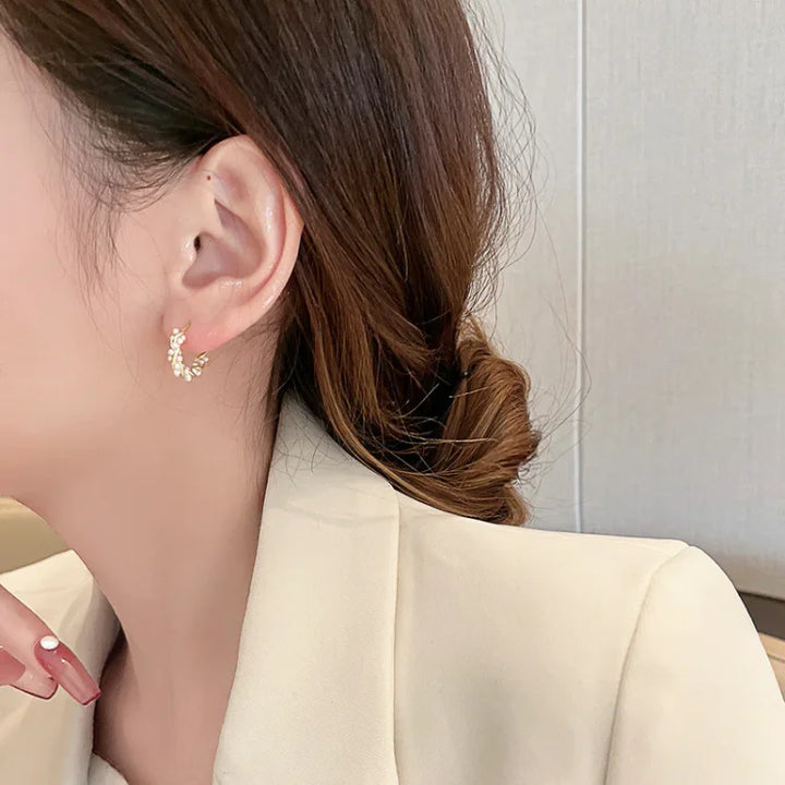 Frau mit goldenen Ohrringen, eleganter Schmuck, Nahaufnahme, modisches Accessoire, Damenmode.
