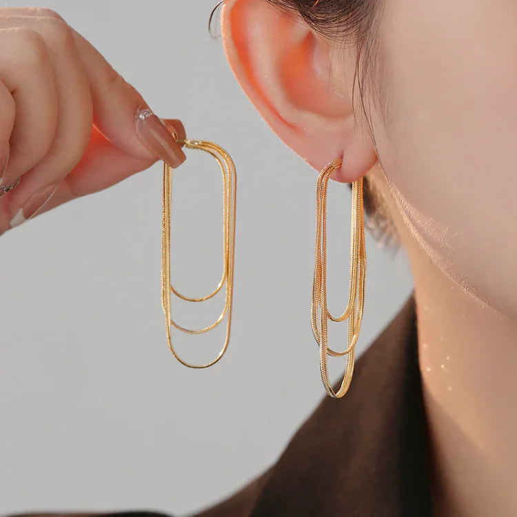 Goldene, lange Ohrringe, geometrisches Design, eleganter Schmuck, Damenmode, Accessoires.