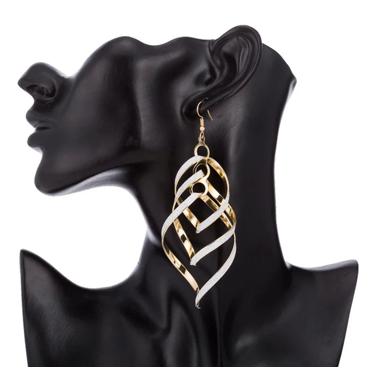 Goldene, spiralförmige Ohrringe an schwarzem Mannequin, Modeschmuck, elegant, modern.