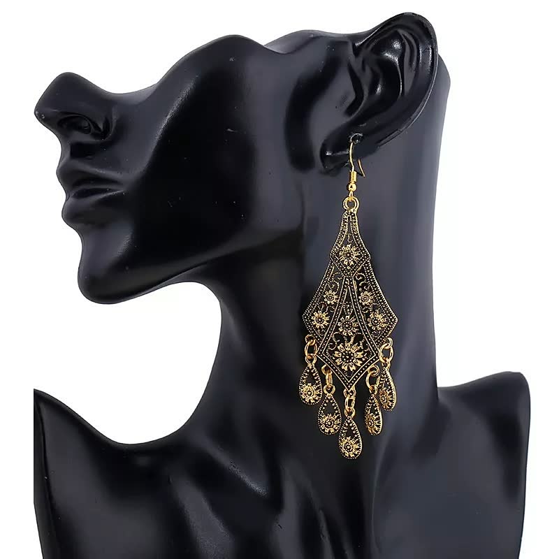 Schwarze Büste mit goldenen, filigranen Ohrringen, orientalisches Design, Modeschmuck.