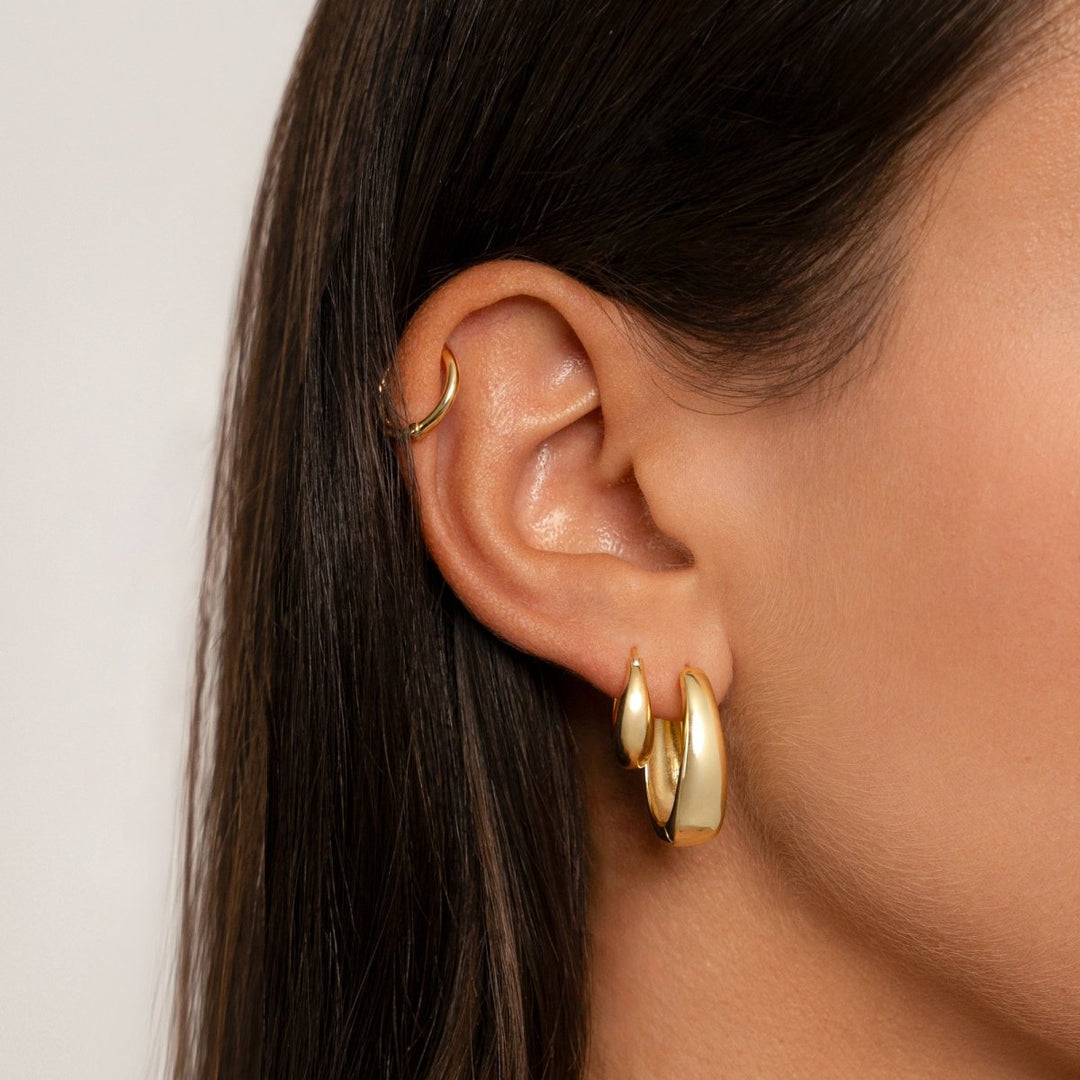 Frau mit goldenen mittelalterlichen Ohrringen, eleganter Schmuck, Nahaufnahme.