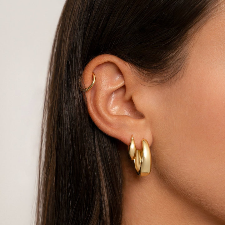 Frau mit goldenen mittelalterlichen Ohrringen, eleganter Schmuck, Nahaufnahme.