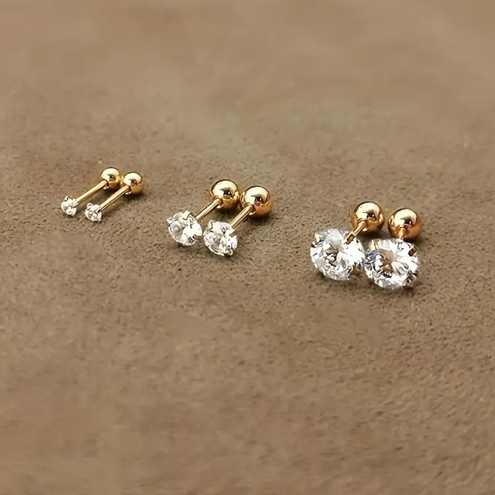 Goldene Ohrstecker mit klaren Zirkonia, drei Größen, eleganter Schmuck, glänzend, modisch.