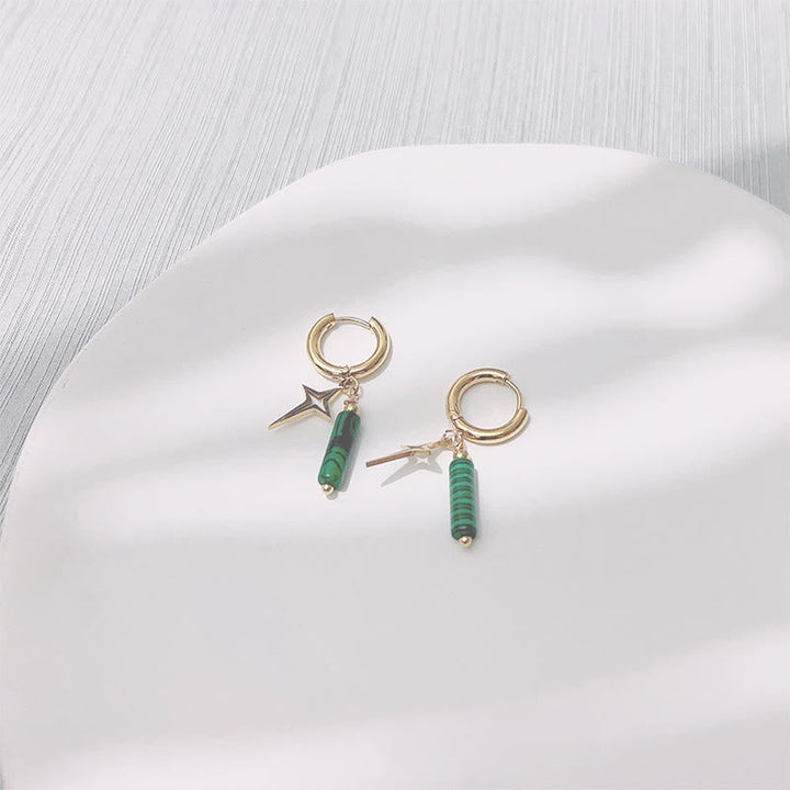 Goldene Creolen mit grünen Anhängern und Stern, modische Ohrringe, Schmuckaccessoire.