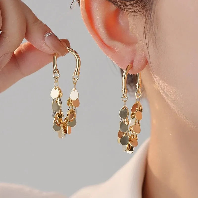 Goldene Ohrringe mit tropfenförmigen Anhängern, eleganter Schmuck für Damen.